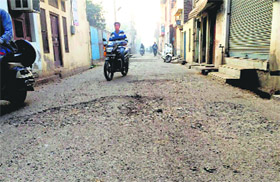 A potholed road in Mandi Ahmedgarh.