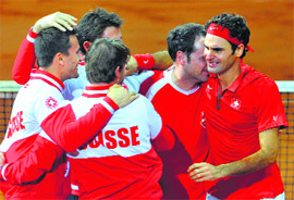 Switzerlands Roger Federer cries as he celebrates with his team after beating Frances Richard Gasquet in the fourth rubber to give Switzerland its first Davis Cup title on Sunday