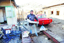 A resident clears a fragment of a Grad rocket launcher from his house destroyed as a result of shelling between Ukrainian forces and pro-Russian militants in Donetsk on Sunday