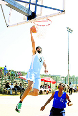 A PU team member aims to score a basket during the Inter-college Basketball Championship for Men on the university grounds in Chandigarh on Monday. 