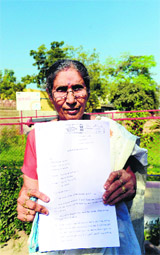 PM Narendra Modis wife Jashodaben holds a copy of the RTI in Mehsana, 70 km from Ahmedabad, on Monday