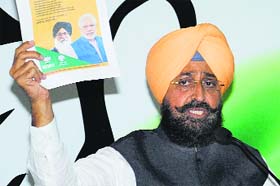 Pics dont lie! Addressing the media in Chandigarh, PPCC chief Partap Bajwa shows BJP ads promising an end to the drug trade in Punjab
