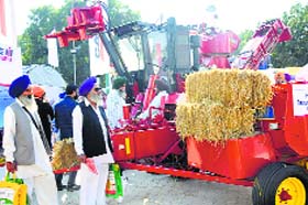 Visitors take a look at a farm equipment on display at CII Agro Tech in Chandigarh on Sunday