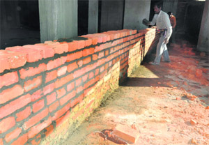 A wall being built by the DMC at the Pacific Hills apartments in Dehradun.