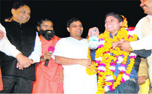 Young magician Anchal Kumawat being greeted by Swami Ramdev, Acharya Balkrishan, and Health Minister Surendra Singh Negi (extreme left) after she performed daring stunts at the Rishikul ground in Haridwar on Sunday