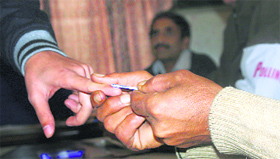 A polling officer puts a mark with indelible ink on a voters finger at Muthi in Jammu on Tuesday.