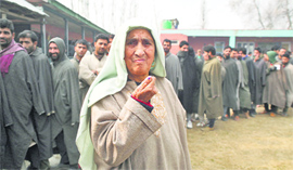 An elderly woman shows the indelible ink-marked finger after casting her vote at Sumbal in Sonawari .