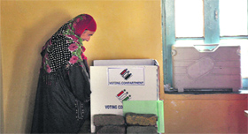 A woman casts her vote at a polling station in Kangan