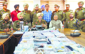 Hardial Singh Mann, Patiala SSP, shows arms and valuables recovered from robbers in Rajpura on Tuesday