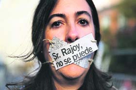 Silent protest: An Amnesty International activist poses with her mouth covered during a protest against the Spanish governments new security law in Madrid