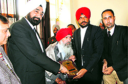District and Sessions Judge Tejwinder Singh honours a veteran lawyer during a function to mark National Law Day in Bathinda on Wednesday