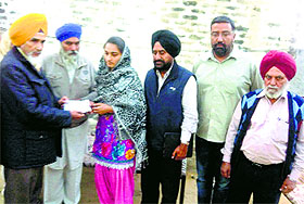 AAP leader Sucha Singh Chhotepur presents a cheque to the kin of the victims in Ludhiana. 