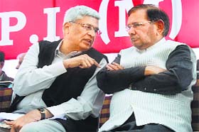 CPM general secretary Prakash Karat speaks with JD-U chief Sharad Yadav during a rally in New Delhi on Wednesday