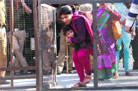 Session blues: A woman carrying a child faces difficulty in commuting due to barricades placed at Rispna Bridge for the Assembly session in Dehradun on Wednesday