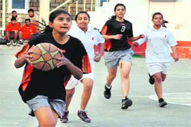 Players of Welham Girls School (black) and Hope Town (white) battle for the ball during a match in the Under-15 District Level Basketball Championship for Boys and Girls at Doon International School on Wednesday