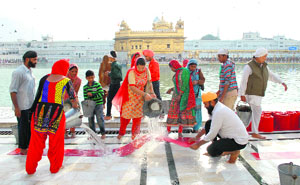Devotees perform sewa inside the Golden Temple complex in Amritsar on Thursday.