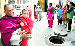 Relatives of the two-year-old child Chirag at the Bashirpura locality in Jalandhar on Thursday. Irate people stand by the gutter in which the child had fallen