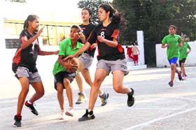 Players of St Mary (green) and Welham Girls (black) try to take control of the ball during a match in the Under-15 District-Level Basketball Tournament at Doon International School in Dehradun on Thursday