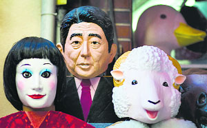 A mask of Japanese Prime Minister Shinzo Abe (C) for sale in Tokyo on Thursday. Japanese voters head to the polls on December 14 for a snap election called by Abe.