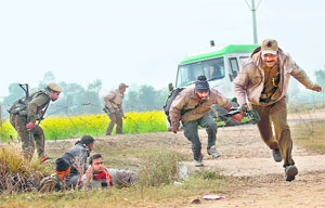 Security men and locals seek shelter during a militant attack in the Arnia sector in Jammu