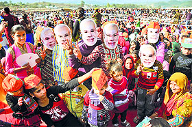 Supporters of the BJP wear masks of Prime Minister Narendra Modi during his election rally in Udhampur district on Friday. 