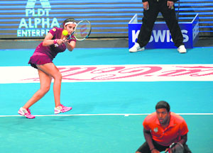 Sania Mirza of the Indian Aces hits a backhand return as teammate Rohan Bopanna waits at the net during the first match of the IPTL in Manila on Friday.