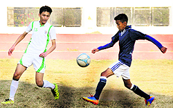 Players of Army Public School (blue) and Delhi Public School (white) try to get the ball during a match in the 6th ONGC Ram Bahadur Chettri Memorial Football Tournament at Ambedkar Stadium in Dehradun on Friday