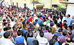 People gathered outside the house of the family members of the girl, who was raped and killed, when Chief Minister Harish Rawat visited the family in Haldwani on Friday