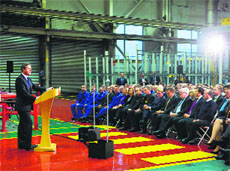 British Prime Minister David Cameron (L) delivers a speech on immigration to factory workers in Rocester on Friday