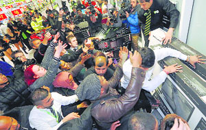 Shoppers compete to purchase retail items on Black Friday at an Asda superstore in Wembley, north London, on Friday
