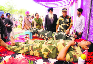 BSF jawans donate blood during a medical camp at Attari near Amritsar on Saturday. 