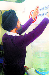 ADC (Development) Supreet Singh Gulati pastes an anti-tobacco poster on a wall in Ludhiana. 