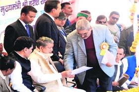 Manmohan Singh Mall, president of the Mussoorie Muncipal Council, takes up demands of people of the Jaunpur region with Chief Minister Harish Rawat at a function at Garkhet village on Saturday