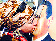 A supporter of former Egyptian President Hosni Mubarak (R) kisses his poster in Cairo on Saturday