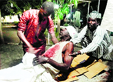 Relatives look after a victim of twin suicide blasts at Kano central mosque in northern Nigerias largest city of Kano