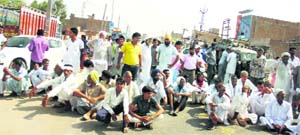 Farmers block traffic as they sit on a dharna on the national highway outside the grain market in Abohar on Monday